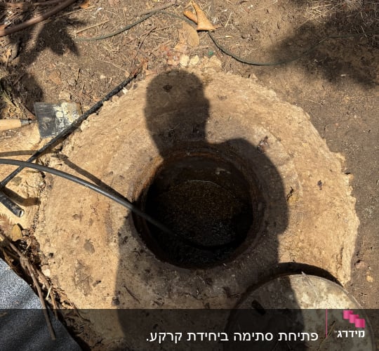 פתח ביוב עם צינור וכלים מסביב